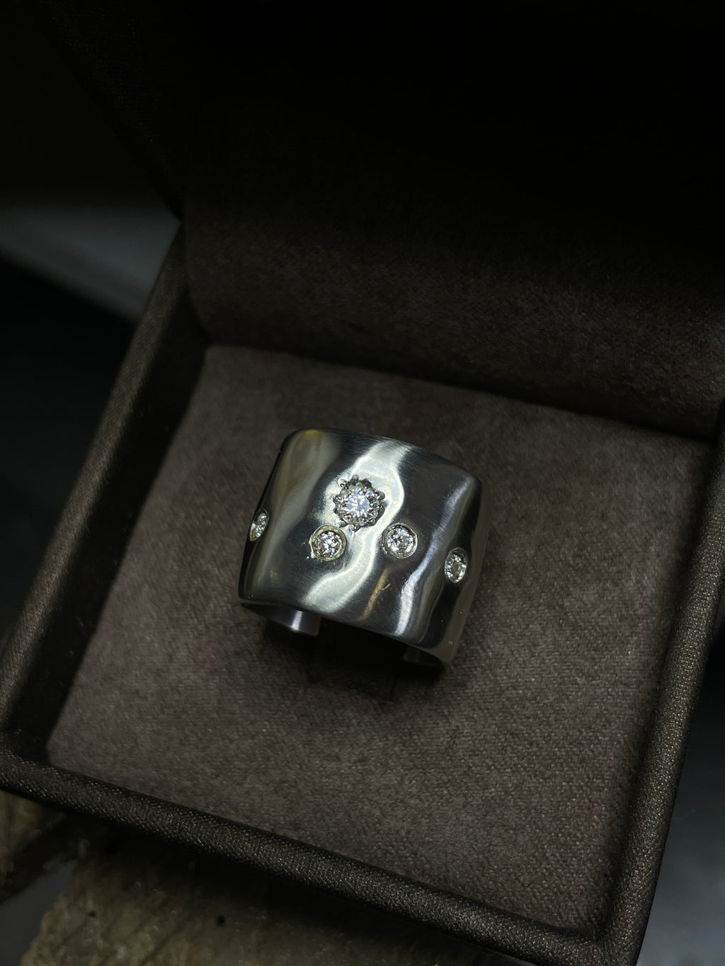 Silver ring with moissanite in a brown box