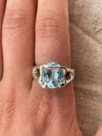 Bespoke silver ring with topaz on finger.