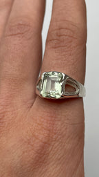Bespoke silver ring with a green amethyst on a finger 